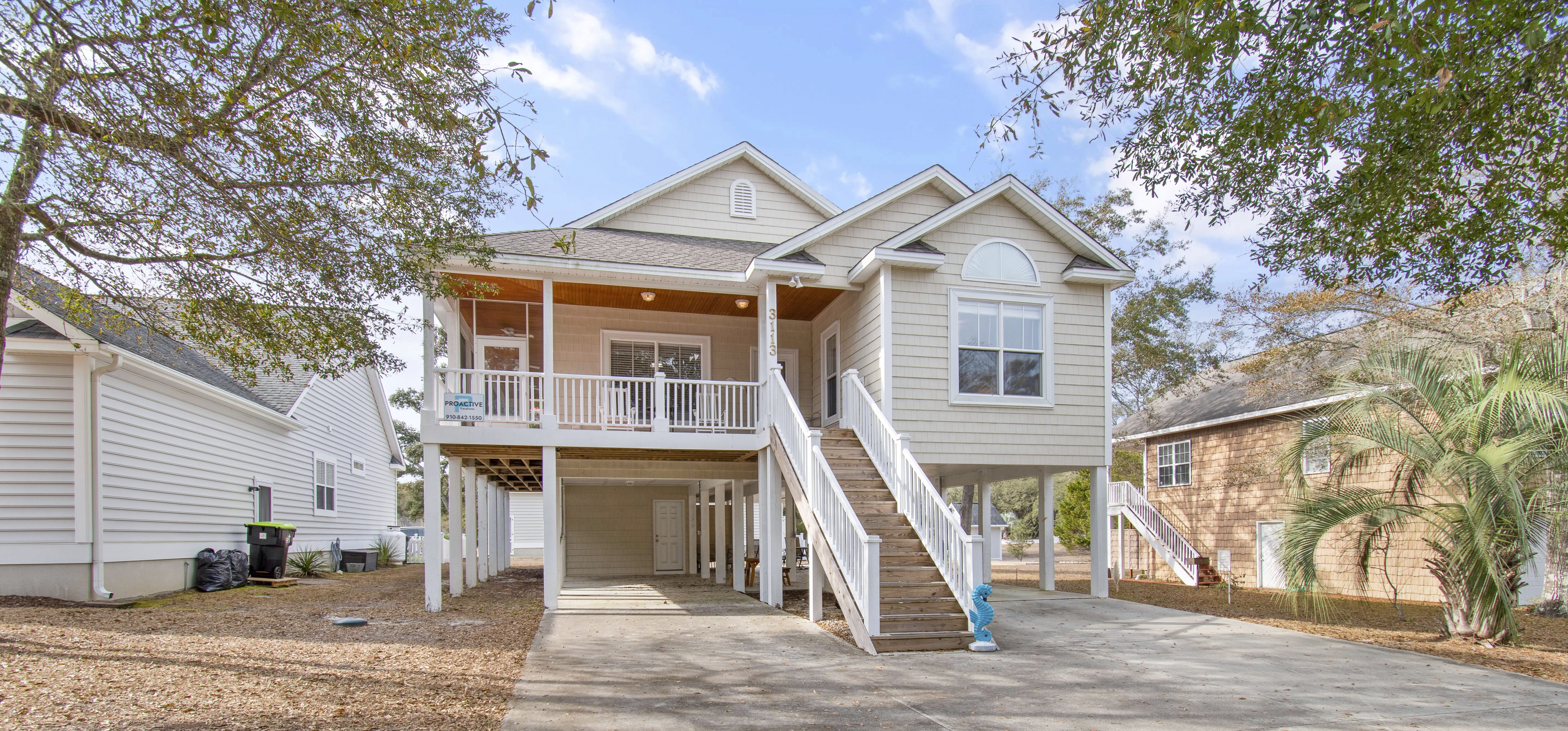 Front view of Old Ferry Coastal Retreat vacation home in Holden Beach with ample parking and 3-night minimum rental sign