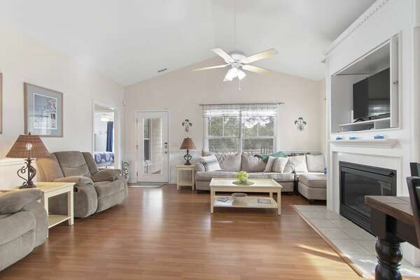 Open living room with ceiling fan, fireplace, and ample seating at Holden Beach rental