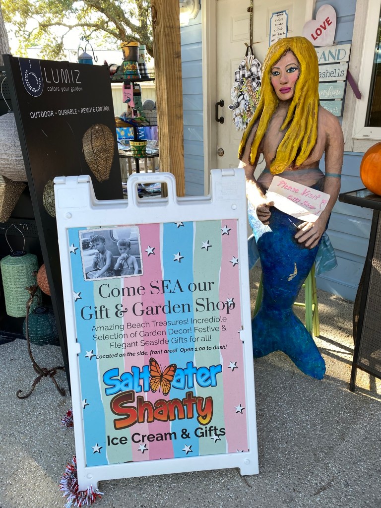 Colorful sign in front of Saltwater Shanty with a mermaid statue