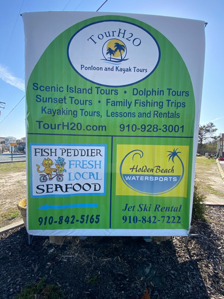Sign advertising TourH2O’s dolphin and kayak tours